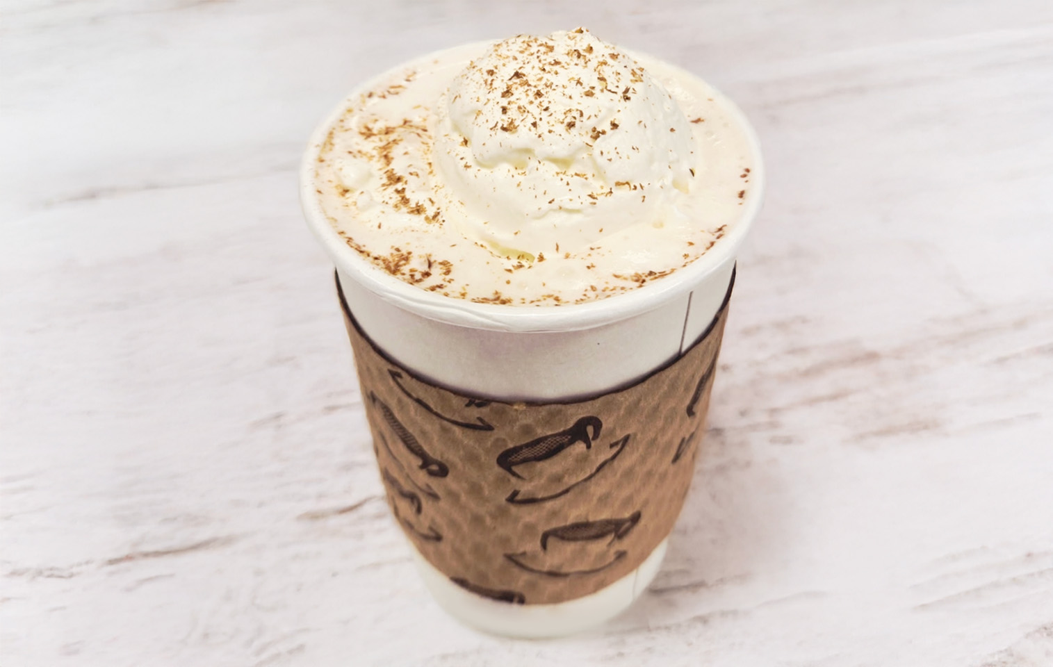 chai latte topped with whip cream and cinnamon sprinkles