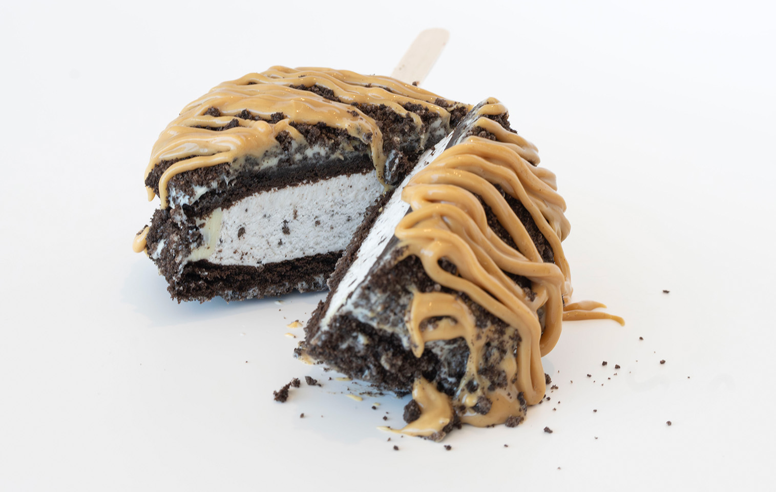 oreo ice cream sandwich covered in oreo cookie crumbs and peanut butter drizzle