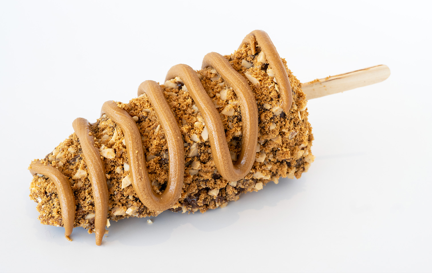 slice of cheesecake dipped in chocolate, covered with the playdate toppings, and drizzled with nuttella 