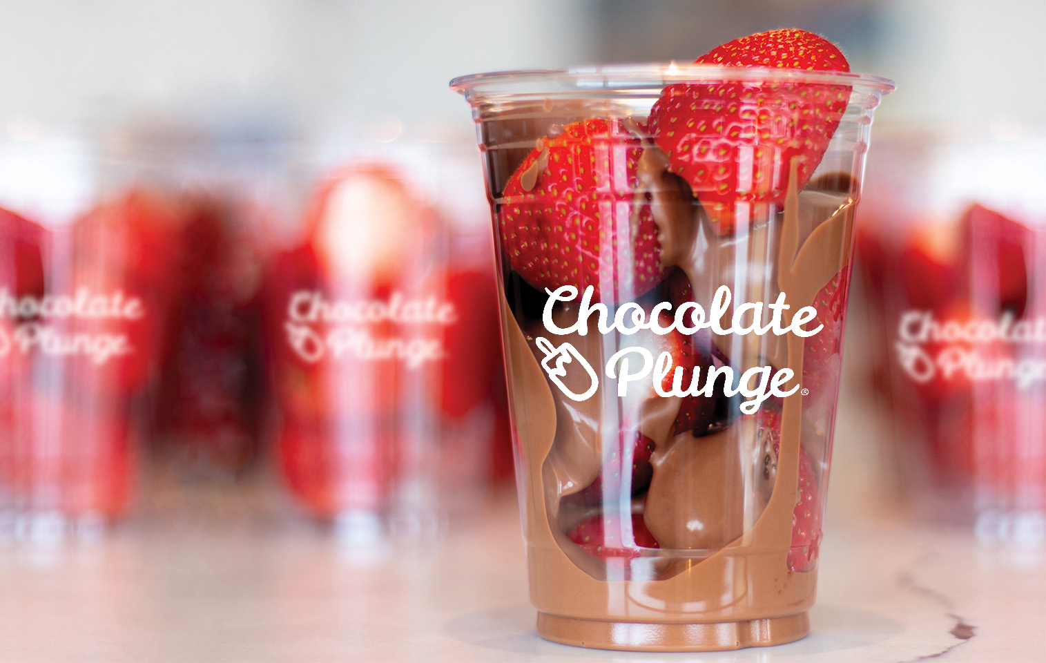 large strawberries in cups drizzled in milk chocolate