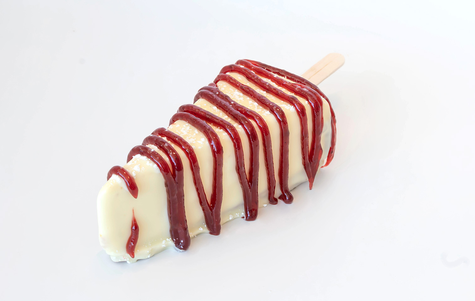 cheesecake dipped in white chocolate and covered with raspberry drizzle